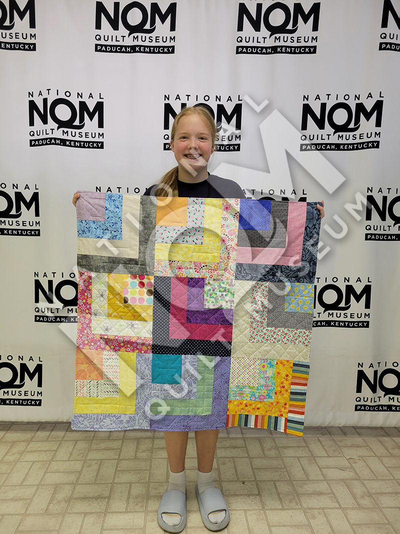 NQM Kids Camp Beginner Level Participant With Finished Quilt